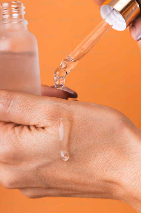 Clear serum dropped from a pipette onto the back of a hand